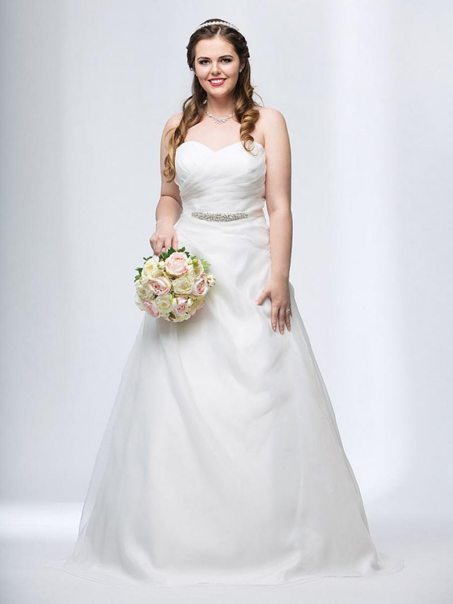Lächelnde Curvy Braut in einem Brautkleid in großer Größe