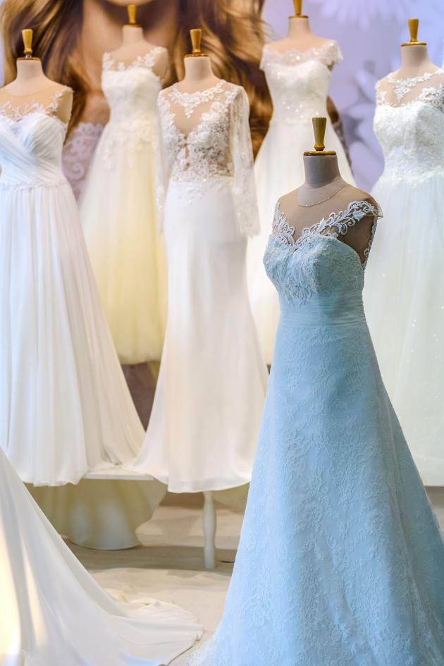 Mehrere Schaufensterpuppen zeigen verschiedene Hochzeitskleider in Weiß und Hellblau.