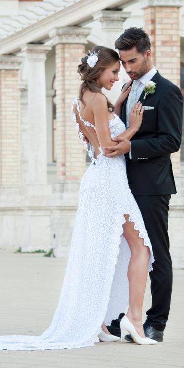 Ein romantisches Paar in Hochzeitskleidung steht vor einer Kulisse aus klassischer Architektur.